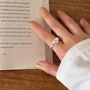 Minimalist 925 sterling silver irregular heart open ring worn in a cozy reading scene