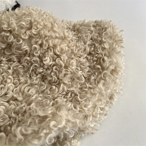 Close-up of beige plush faux shearling fabric texture for a warm winter bucket hat