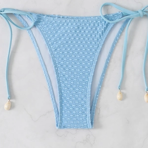 Close-up of light blue textured bikini bottom with decorative side ties and shell charms