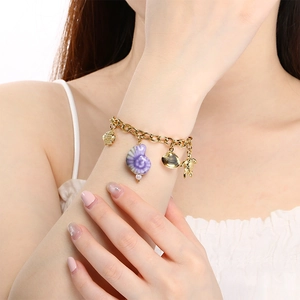 Vue détaillée du bracelet doré avec pendentifs coquillage violet, tortue dorée et pétoncle