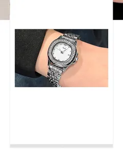 Detailed macro of a silver women's watch with rhinestone bezel and calendar display