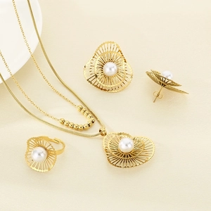 Detailed view of gold-plated stainless steel jewelry set with white pearls and flower design