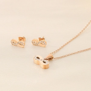 Macro detail of 18k rose gold infinity necklace and stud earrings with shiny crystals