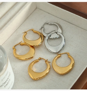 Three pairs of U-shaped horseshoe metal earrings in gold and silver finish in a jewelry box