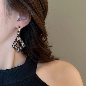 Gros plan de boucles d'oreilles léopard géométriques avec texture en similicuir et bord noir