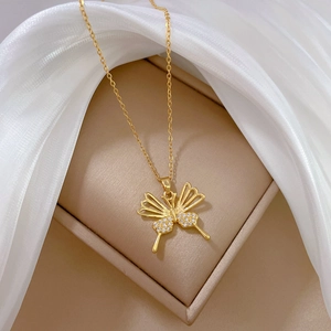 Elegant gold butterfly necklace with zircon wings on a soft silk and jewelry box background