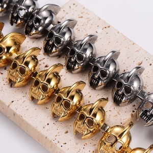 Macro view of detailed skull link bracelet parts in gold and silver finish on stone