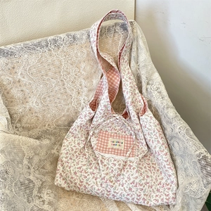 Detail of floral canvas tote bag with pink lace trim and ribbon bow decoration
