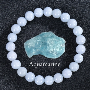 Detail of round light blue aquamarine beads with high gloss on a black texture