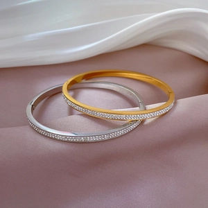 Elegant gold and silver titanium steel bracelets with pavé zircons on silk fabric