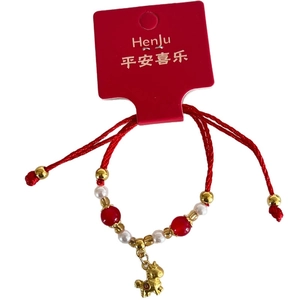 Red braided rope bracelet with golden horse charm and white pearls on card