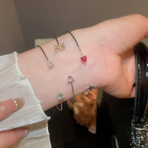 Close-up of zircon star and water drop open bracelets worn together on a model's wrist