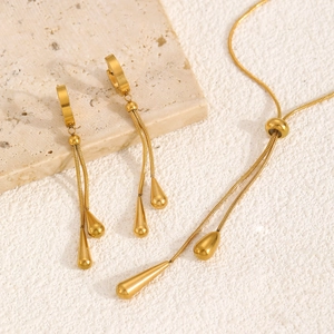 Detailansicht von goldenem Wassertropfen-Anhänger und langen Quasten-Ohrringen Schmuckset