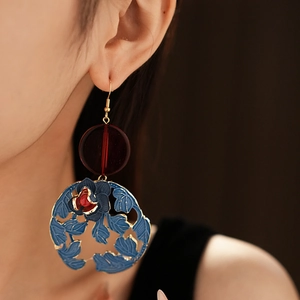 Detail of vintage flower drop earrings with red beads and blue floral enamel charms