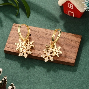 Golden snowflake zircon drop earrings on festive background with professional lighting