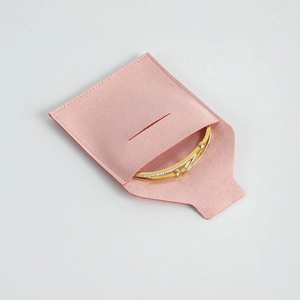 Brazalete dorado con circonitas blancas en una bolsa de microfibra rosa de calidad