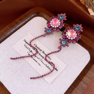 Macro detail of vintage baroque earrings with pink stones, pearls and floral tassels