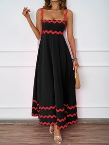 Detail of elegant summer maxi dress featuring red wavy trim and bold black contrast