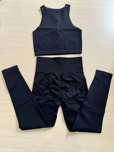Flachbild-Ansicht vom nahtlosen schwarzen Ripp-Sportset mit Crop Top und Push-up Leggings