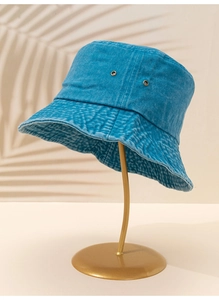 Vue détaillée du chapeau bob en denim bleu avec œillets d'aération métalliques et texture