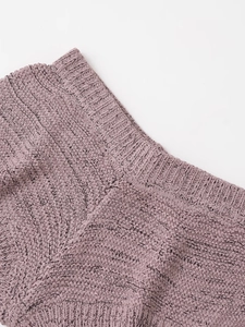 Dettaglio del tessuto in maglia a costine malva che mostra la trama fine e l'artigianalità