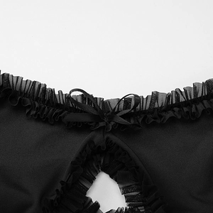 Dettaglio dello scollo con balze in mesh, fiocco di raso e ritaglio sull'abito nero