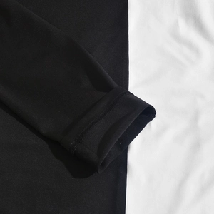 Gros plan sur les coutures contrastées noir et blanc et la maille au poignet de la robe