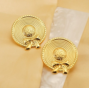 Détail de boucles d'oreilles en acier doré 18K en forme de chapeau de paille tressé
