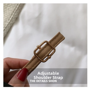 Detail of adjustable khaki leather shoulder strap with polished gold-tone metal buckle