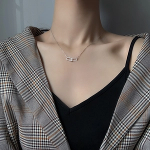 Vista macro di ciondoli rettangolari in argento con cristalli sul collo di una donna
