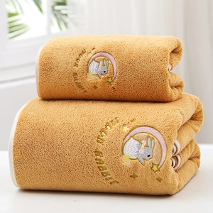 Detail of soft yellow coral fleece towel featuring cute moon rabbit cartoon embroidery