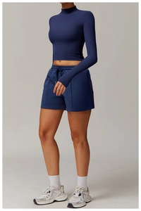 Detail of high-stretch navy blue long sleeve crop top with drawstring gym shorts set