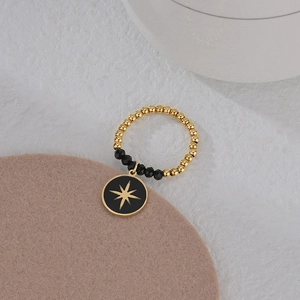 Elastic beaded ring featuring gold and black beads with a North Star medal pendant