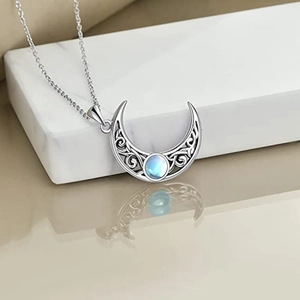 Macro detail of crescent moon pendant with celtic patterns and glowing blue moonstone