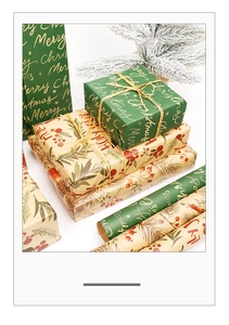 Detail of Christmas kraft gift wrap with red berry patterns and golden Merry Christmas text