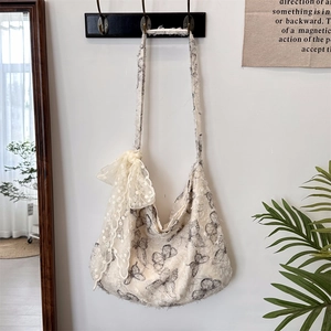 Detailed lace bow decoration and butterfly prints on a casual cream hobo canvas bag
