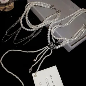 Collier de perles multicouche élégant avec breloques cœur et ailes en argent sur fond noir