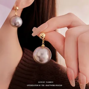 Minimalist gold plated grey pearl stud earrings for women with a luxurious metallic luster
