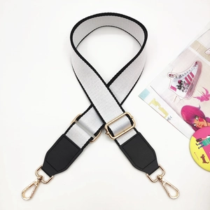 Adjustable black and white canvas shoulder strap with gold metal hooks and leather accents