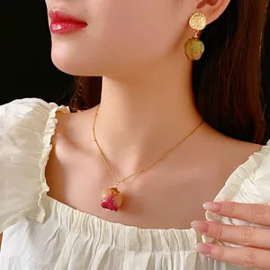 Preserved pink rose bud jewelry set with golden necklace and earrings on model
