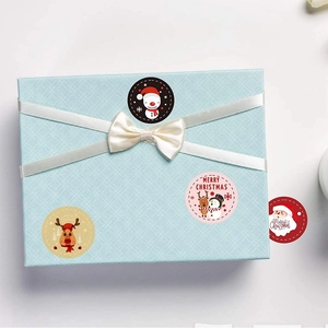 Christmas round stickers on light blue gift box with Santa and Reindeer designs