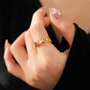 Détail d'une bague pièce dorée avec pierre œil de chat sur main, plan serré