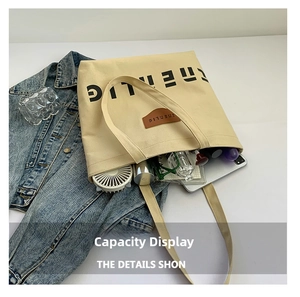 Large beige canvas tote bag interior showing capacity with notebook and gadgets