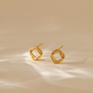 Minimalist square crossed stud earrings in 18K gold finish with white diamonds