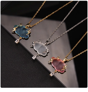 Detailed view of cloud and lightning necklaces with crystal droplets and metal chains