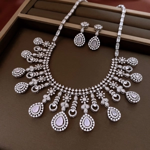 Detailed view of silver zircon jewelry set with pink teardrop stones in a luxury box