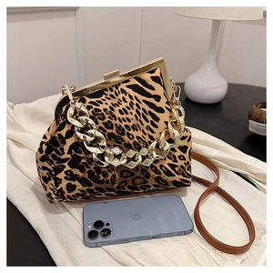 Detail of leopard print shell bag with chunky gold chain handle and metal frame clasp