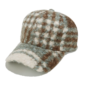 Close-up of the plush faux shearling texture and vintage plaid pattern on the baseball cap