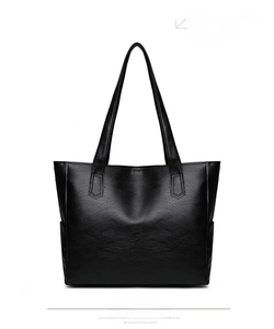 Rear view detail of a black faux leather tote bag with natural pebble grain texture