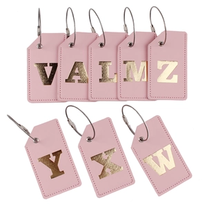 Detailed view of pink PU leather luggage tags with gold foil initials and wire loops